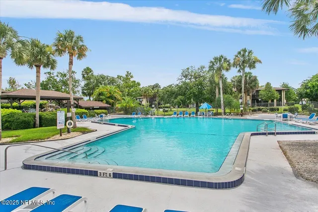 a view of a swimming pool with a garden and trees