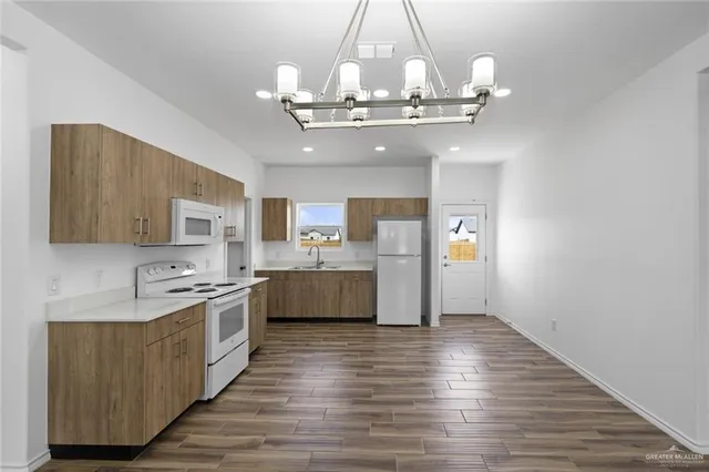a view of a kitchen with a sink and wooden floor