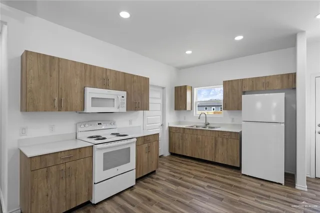 a kitchen with stainless steel appliances a refrigerator sink and white cabinets