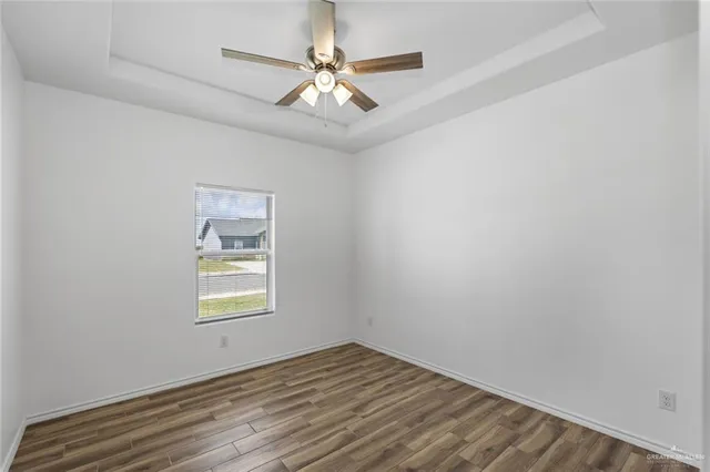 an empty room with a window and a fan