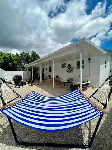 a view of a patio with table and chairs with wooden floor and fence