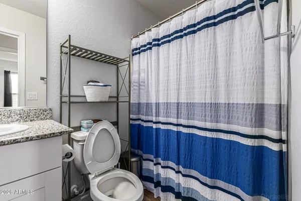 a bathroom with a granite countertop toilet sink and mirror