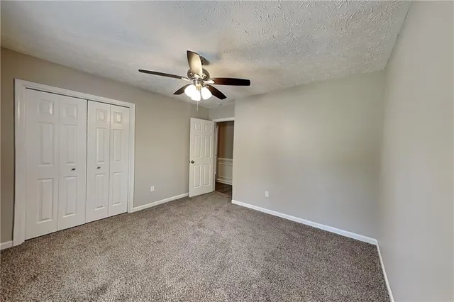 an empty room with a window and a ceiling fan