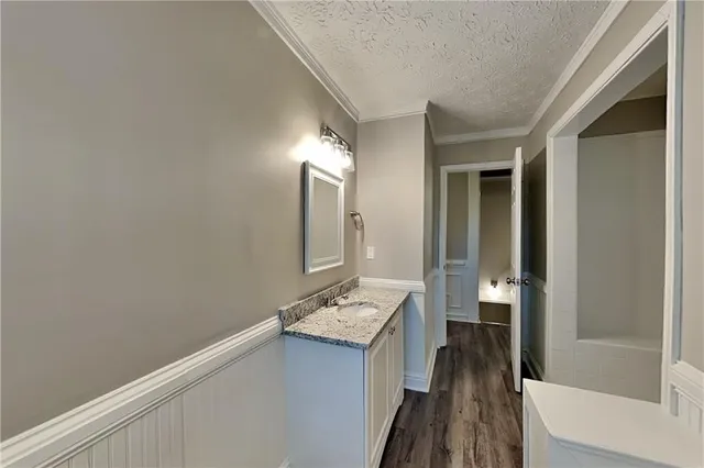 a white bath tub sitting next to a white sink and vanity