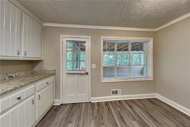 a view of a room with wooden floor and chandelier