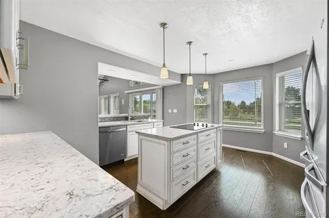 a kitchen with a stove a sink and a wooden floors