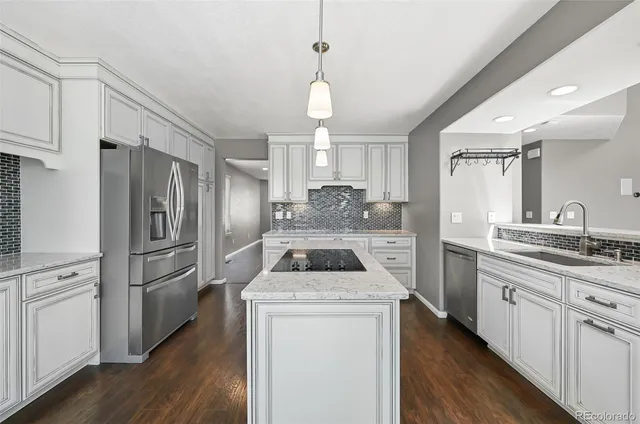 a kitchen with a refrigerator a sink and wooden floor