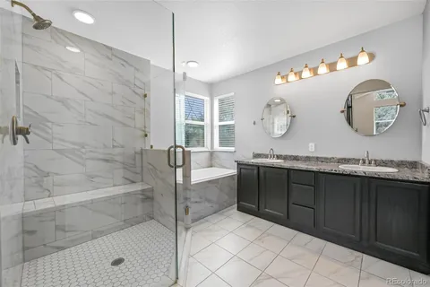 a spacious bathroom with a granite countertop sink mirror and bathtub