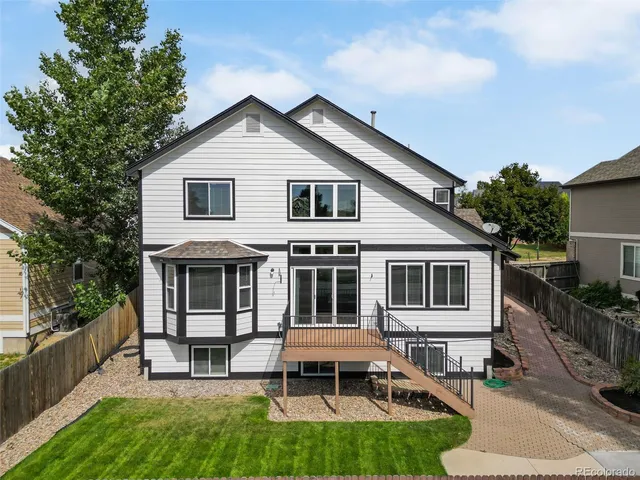 a view of house with a yard and sitting area