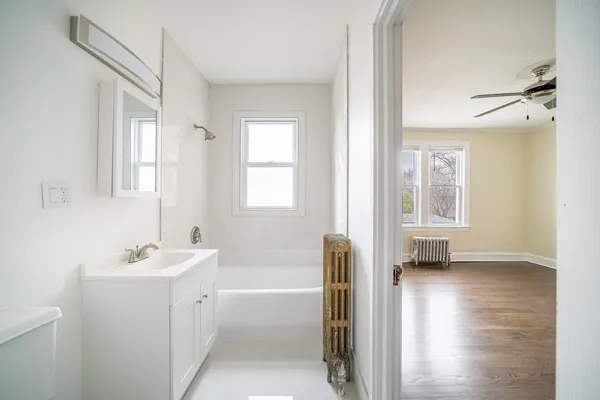 a bathroom with a tub sink and mirror