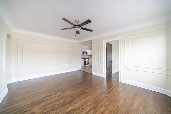 a view of empty room with wooden floor and window