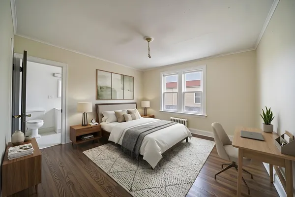 a bedroom with a large bed and windows