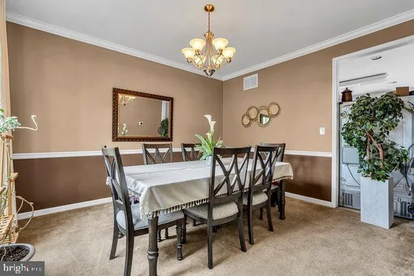 a view of a dining room with furniture and chandelier