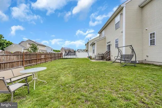 a view of a house with backyard and a tree