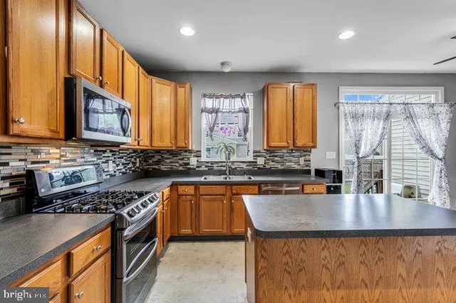 a kitchen with a sink a counter top space cabinets and stainless steel appliances