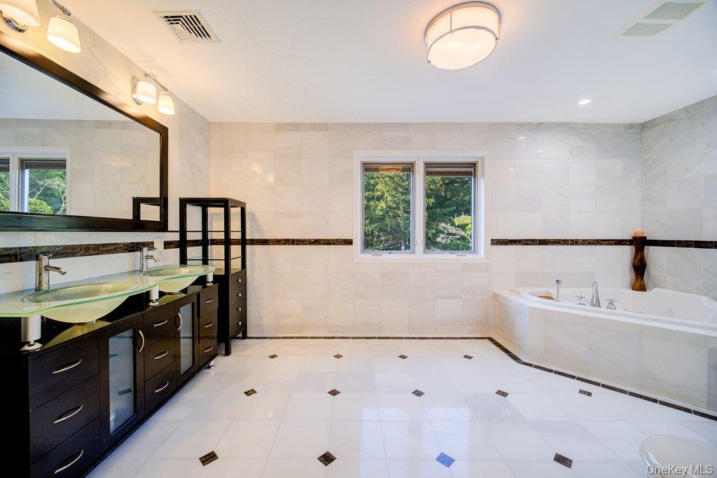 237 Mineral Springs Road Highland Mills, NY 10930 - Photo 23 of 32 Full bathroom featuring tile walls, a garden tub, and light tile patterned flooring