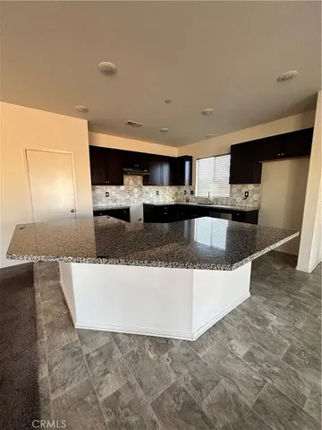 a view of a kitchen with kitchen island a sink a stove a microwave and cabinets