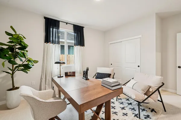 a living room with furniture a potted plant and a table