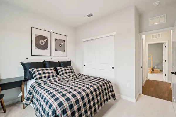 a bedroom with a bed and painting on the wall