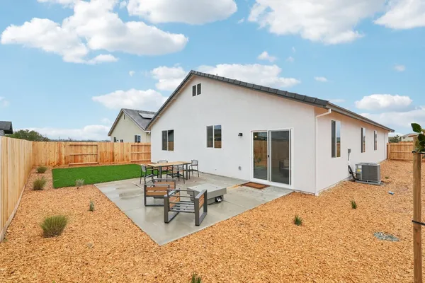 a backyard of a house with table and chairs