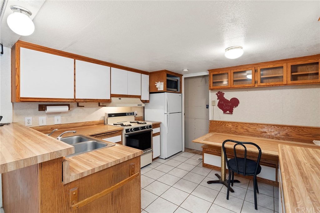 46970 Rainbow Canyon Road Temecula, CA 92592 - Photo 12 of 34 a kitchen with stainless steel appliances granite countertop a sink stove and refrigerator