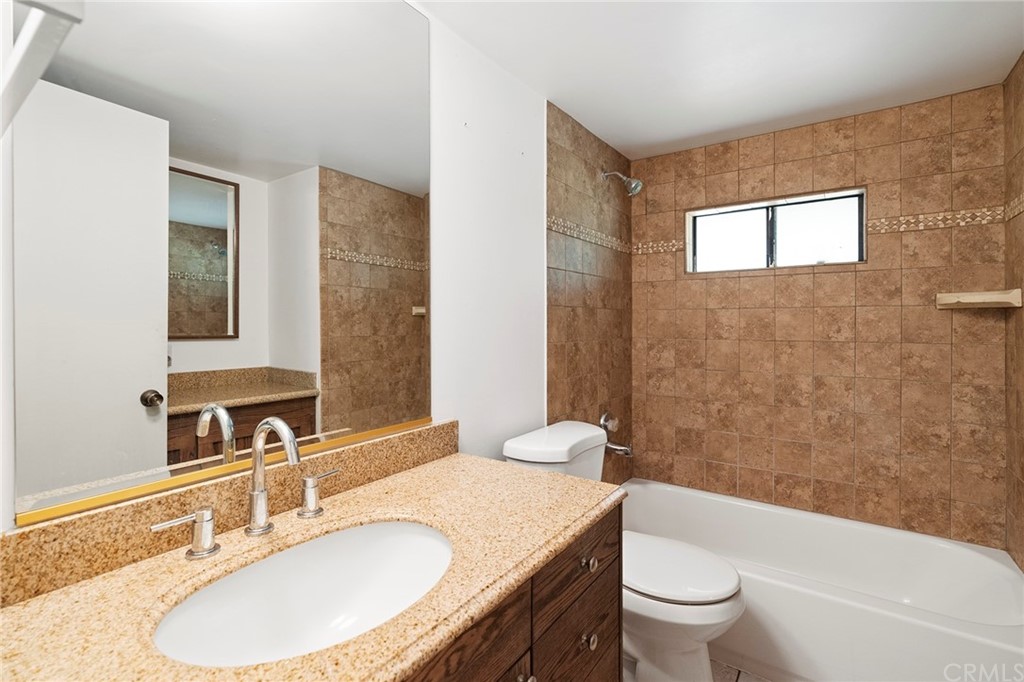 46970 Rainbow Canyon Road Temecula, CA 92592 - Photo 24 of 34 a bathroom with a granite countertop sink toilet a mirror and bathtub