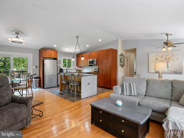 a kitchen with stainless steel appliances granite countertop a refrigerator a sink a stove a dining table and chairs