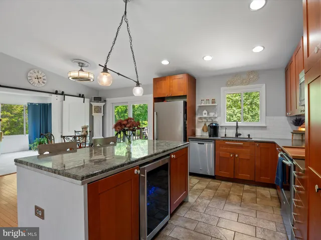 a kitchen with stainless steel appliances a sink a stove a microwave cabinets and a window