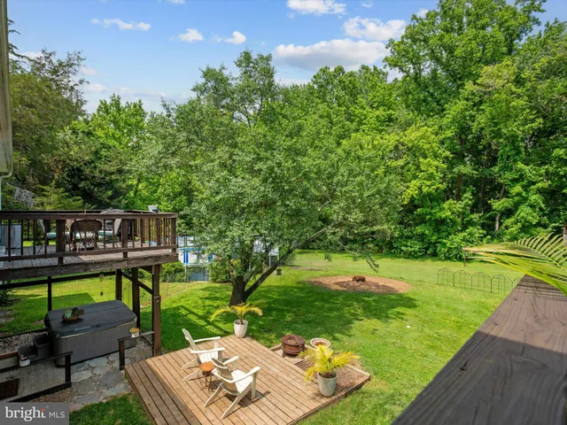 a view of a bedroom with wooden floor & a window