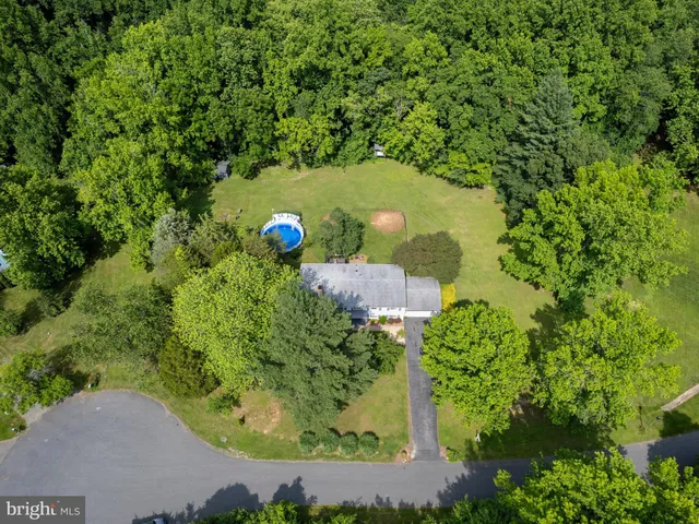 an aerial view of a house with a yard and swimming pool