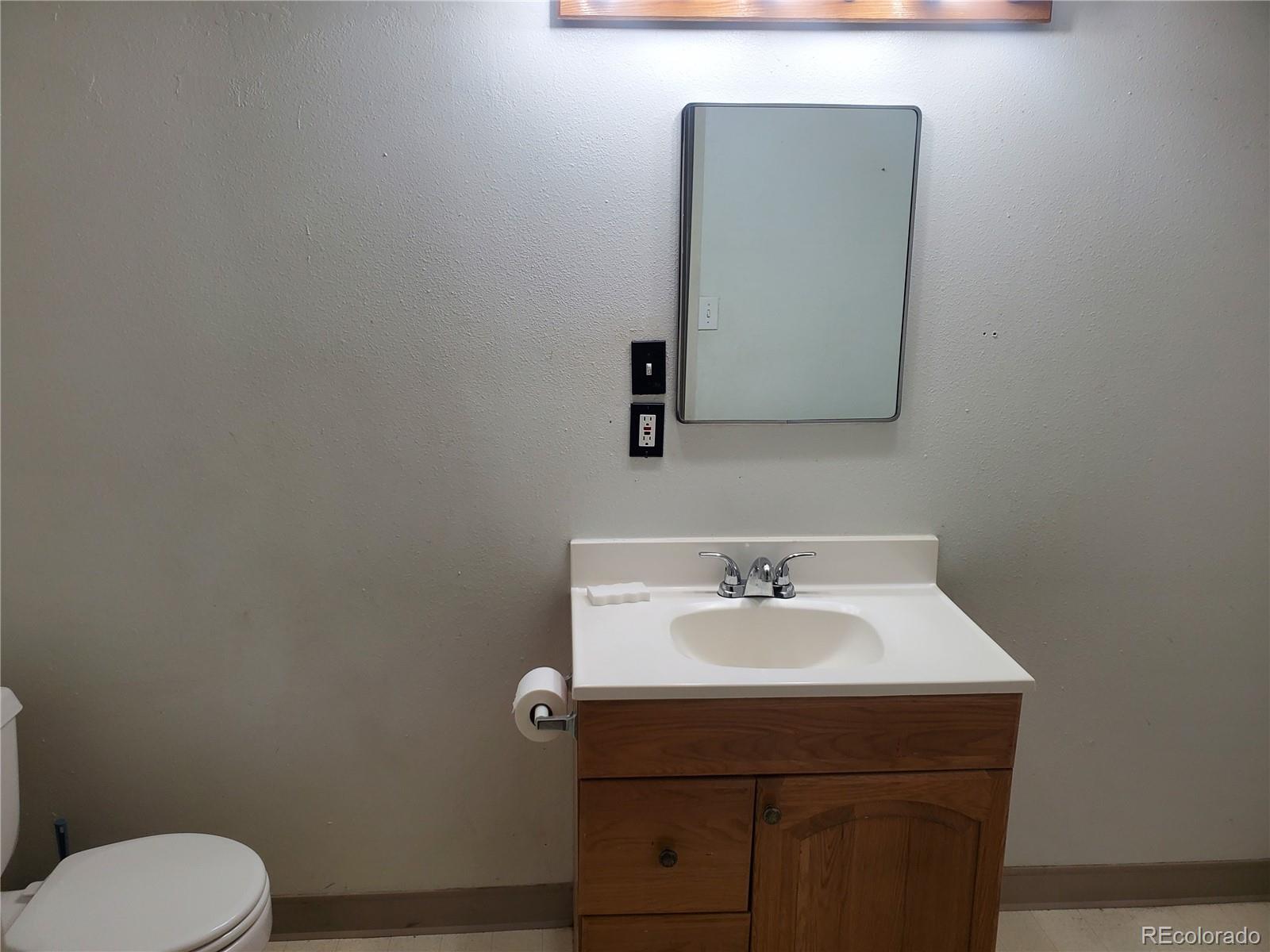 1012 State Street Fort Morgan, CO 80701 - Photo 15 of 18 a bathroom with a sink a toilet and mirror