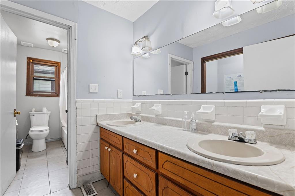 877 Beckwith Street Southwest Atlanta, GA 30314 - Photo 11 of 28 a bathroom with a toilet a sink and mirror