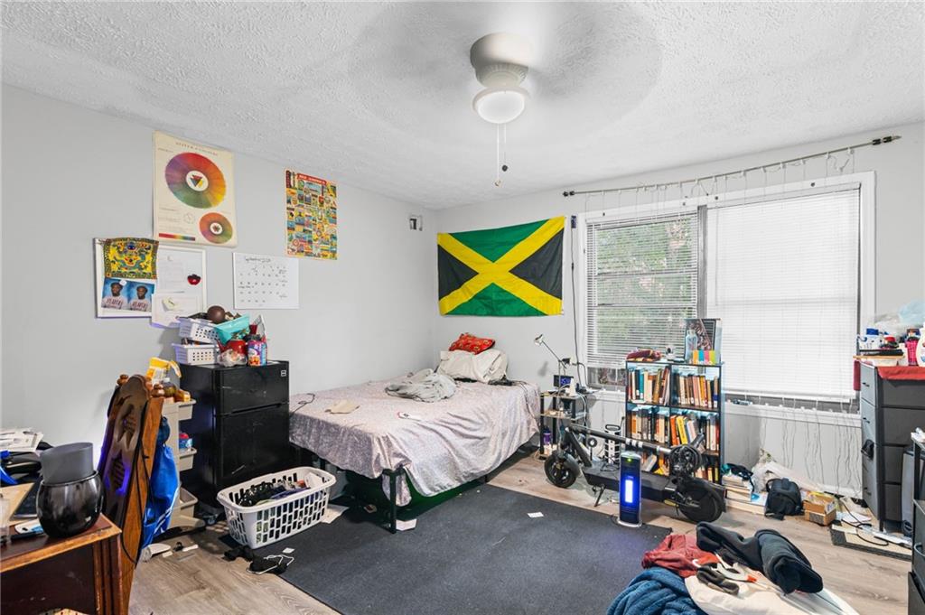 877 Beckwith Street Southwest Atlanta, GA 30314 - Photo 19 of 28 a bedroom with a bed and a chandelier