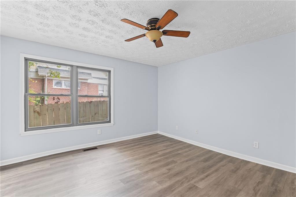877 Beckwith Street Southwest Atlanta, GA 30314 - Photo 24 of 28 an empty room with wooden floor and windows