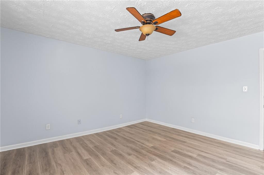 877 Beckwith Street Southwest Atlanta, GA 30314 - Photo 26 of 28 an empty room with a ceiling fan and wooden floor