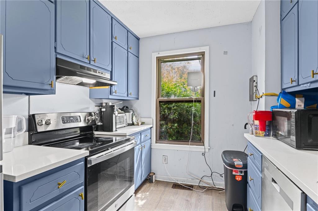 877 Beckwith Street Southwest Atlanta, GA 30314 - Photo 10 of 28 a kitchen with stainless steel appliances granite countertop a sink stove and cabinets