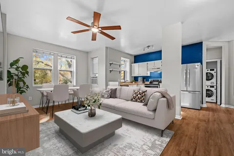 a living room with furniture kitchen view and a window