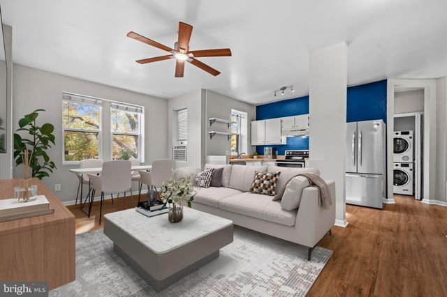 a living room with furniture kitchen view and a window