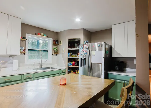 a kitchen with stainless steel appliances granite countertop a refrigerator and a sink