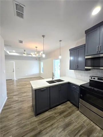 a large kitchen with stainless steel appliances granite countertop a sink and a stove