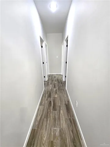a view of a hallway with wooden floor