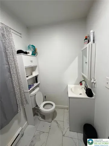 a bathroom with a sink a toilet and a mirror