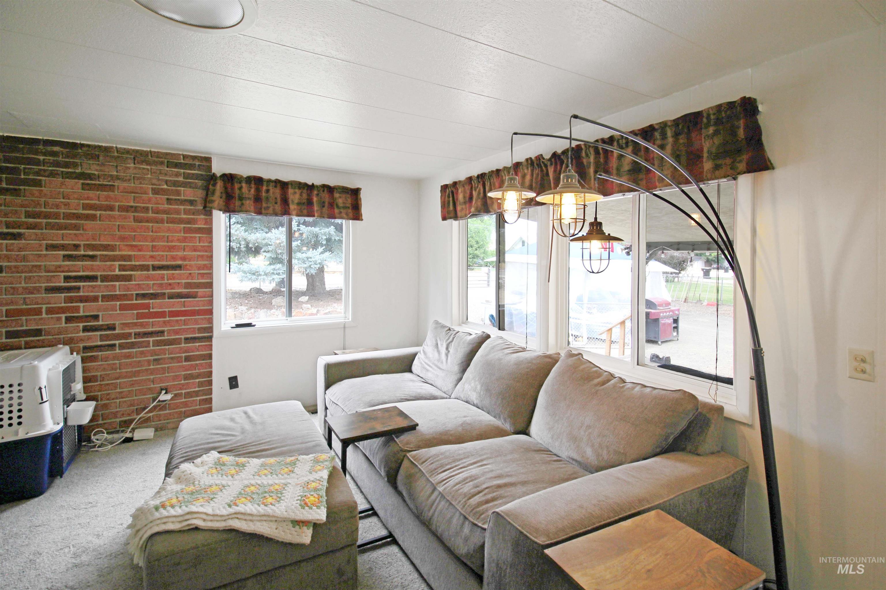 1265 Pioneer Road Weiser, ID 83672 - Photo 12 of 29 Exposed brick accent wall and multiple windows providing natural light