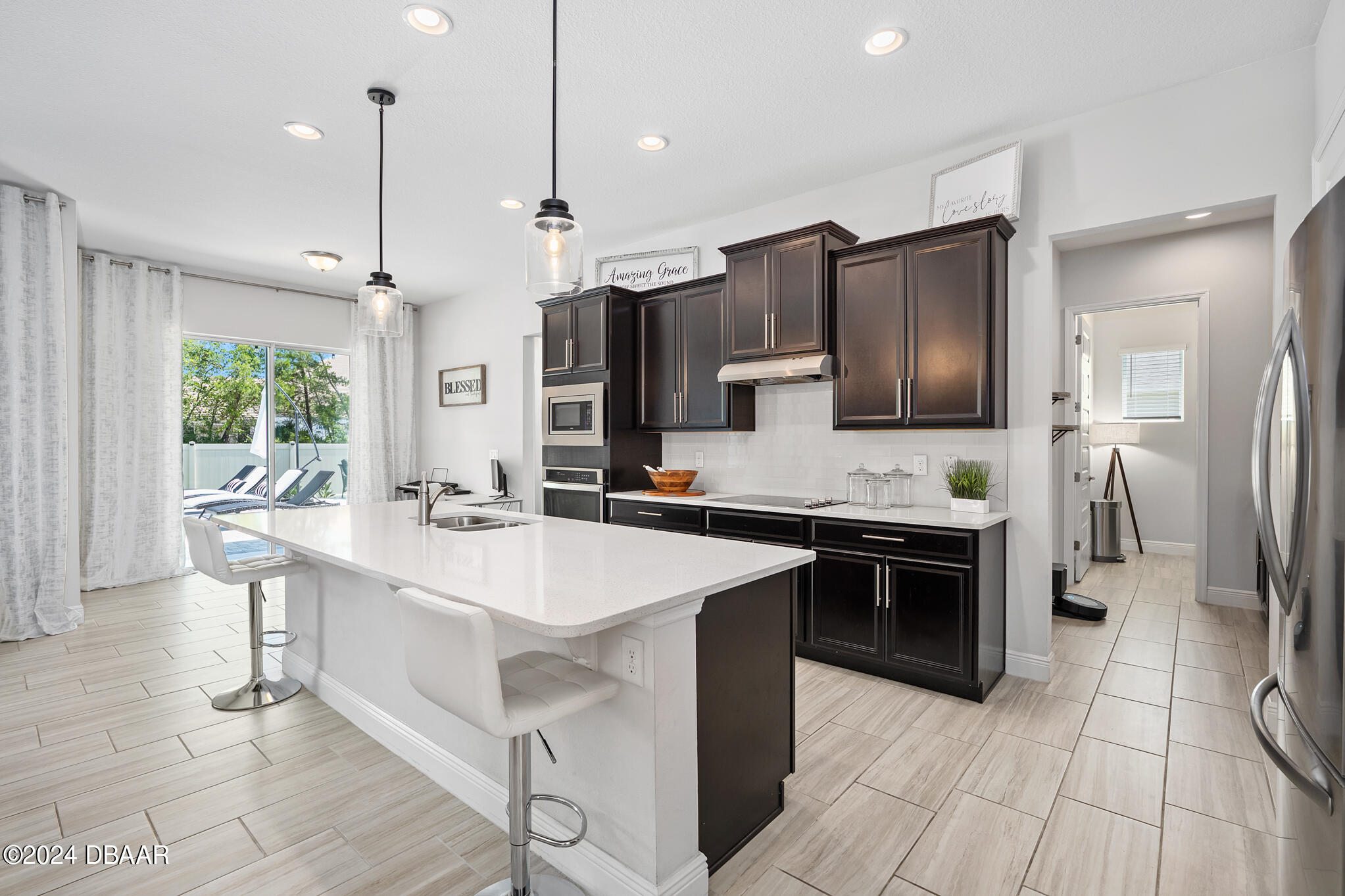 295 Cypress Trail Drive Ormond Beach, FL 32174 - Photo 21 of 67 a large kitchen with stainless steel appliances kitchen island granite countertop a sink a stove a refrigerator and a granite counter tops