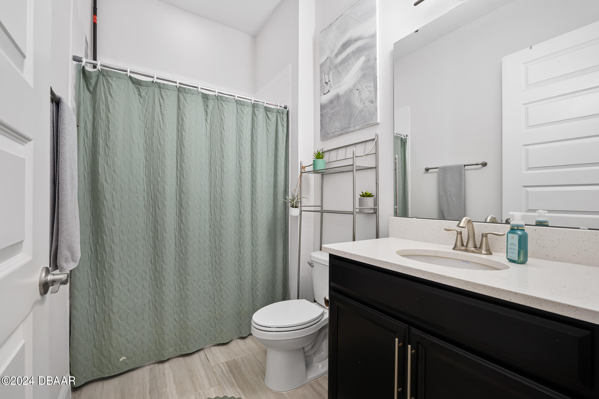 295 Cypress Trail Drive Ormond Beach, FL 32174 - Photo 7 of 67 a bathroom with a sink a toilet a mirror and shower curtain