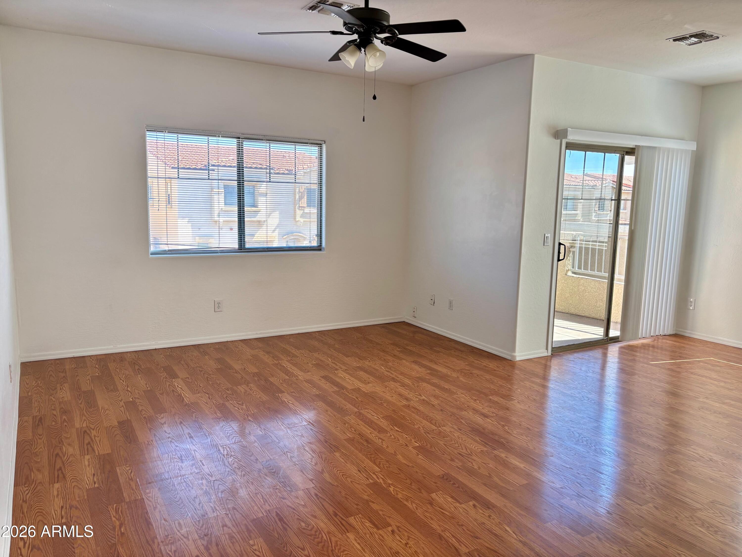 525 North Miller Road, Unit 239 Scottsdale, AZ 85257 - Photo 12 of 52 a view of an empty room with wooden floor and a window