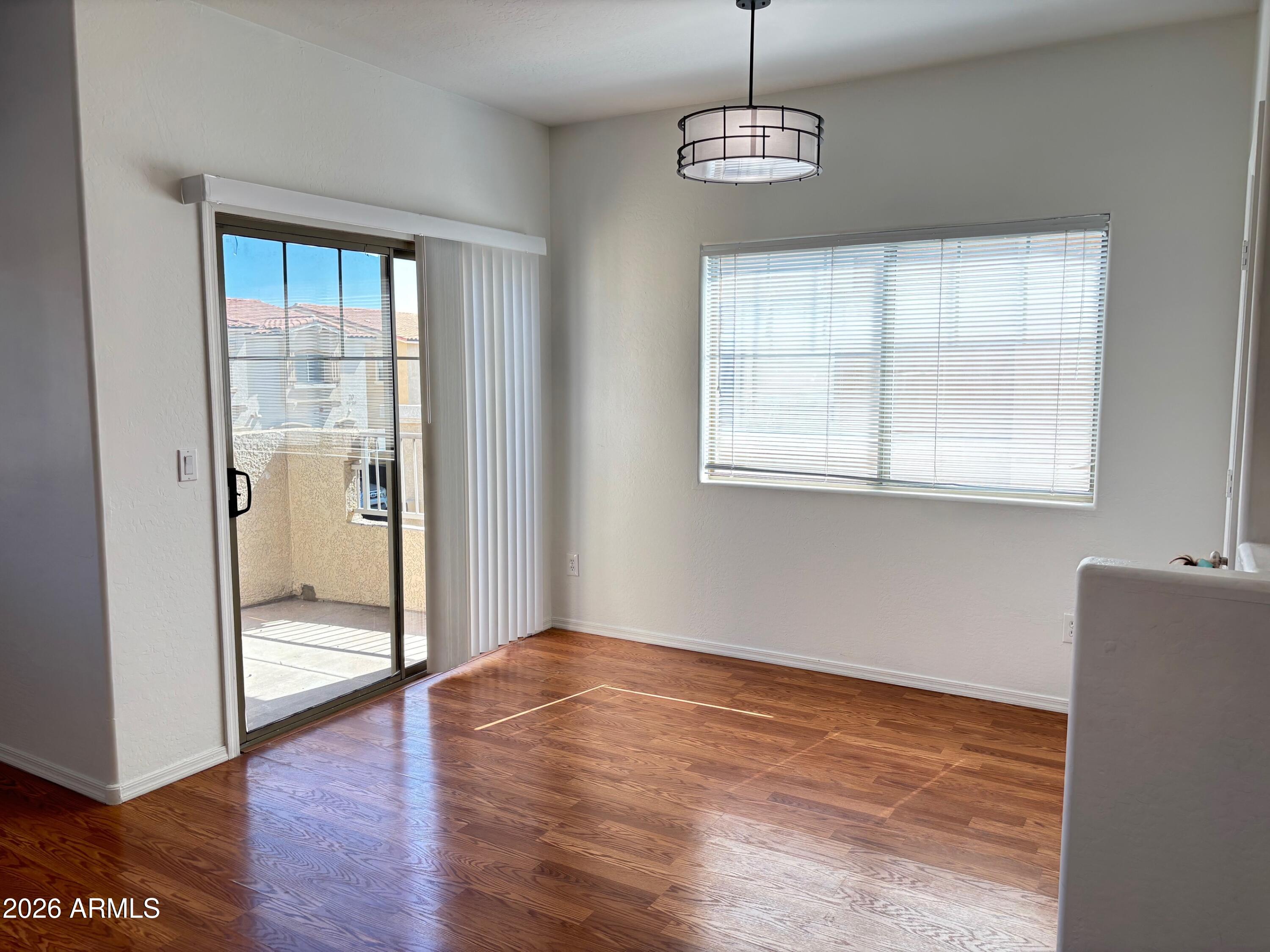 525 North Miller Road, Unit 239 Scottsdale, AZ 85257 - Photo 13 of 52 a view of an empty room with wooden floor and a window