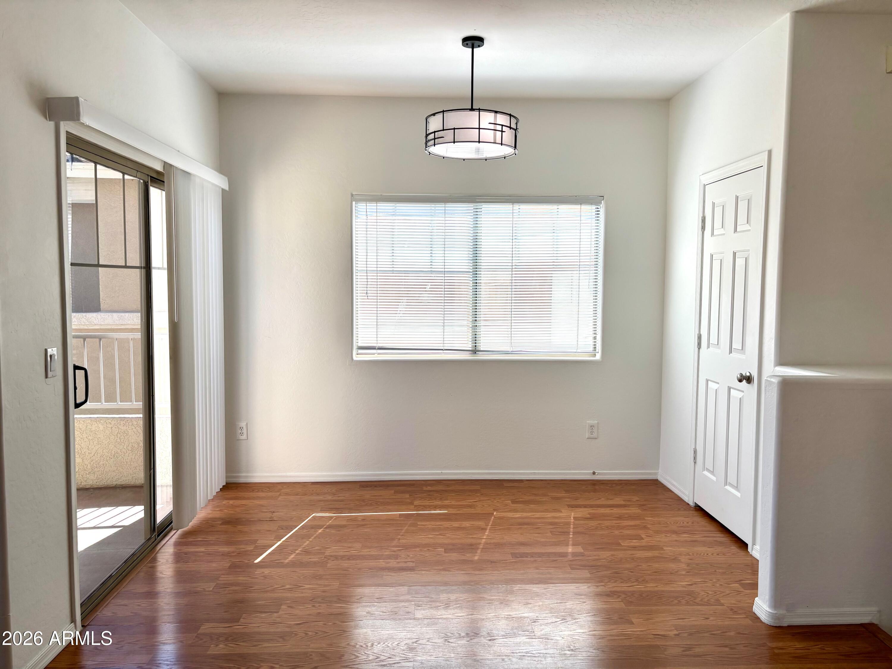 525 North Miller Road, Unit 239 Scottsdale, AZ 85257 - Photo 14 of 52 a view of an empty room with wooden floor and a window