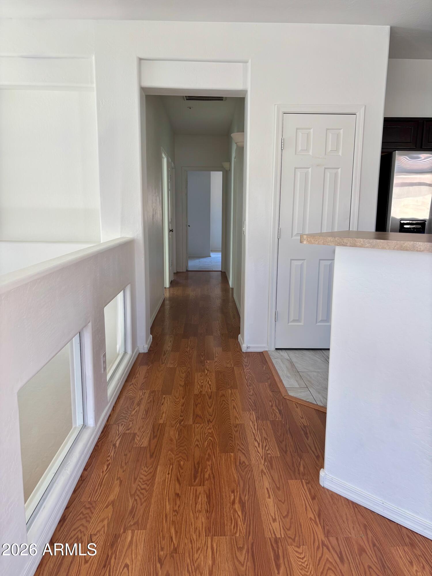 525 North Miller Road, Unit 239 Scottsdale, AZ 85257 - Photo 16 of 52 a view of a hallway with wooden floor and a living room