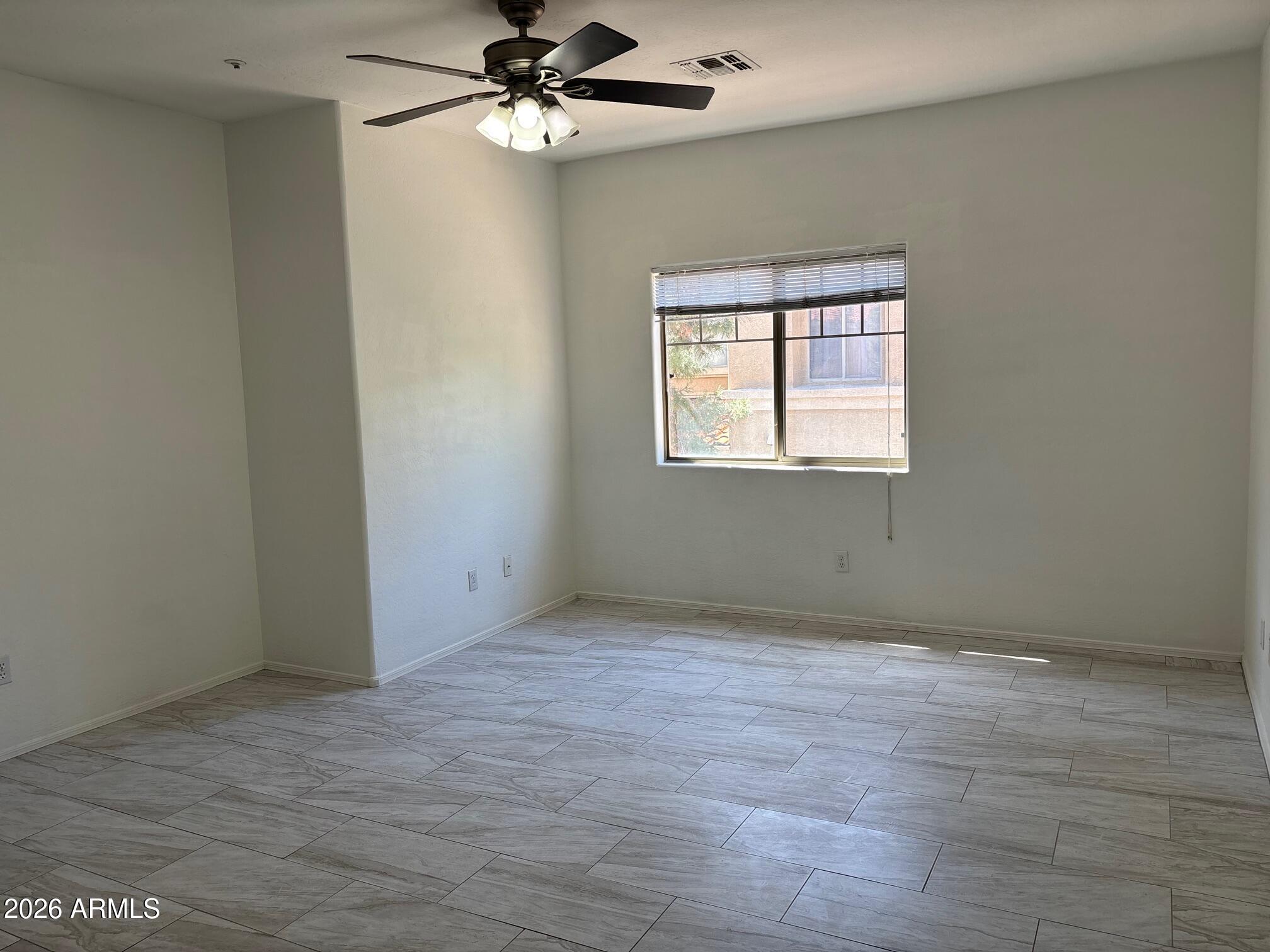 525 North Miller Road, Unit 239 Scottsdale, AZ 85257 - Photo 19 of 52 an empty room with wooden floor fan and windows